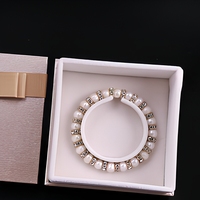 Boîte à bijoux de luxe en papier rigide carré, couleur or champagne, avec ruban et logo personnalisé, pour la présentation de bracelets.