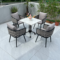 Ensemble de bistro d'extérieur de style français: table en marbre et chaises en rotin pour patio, jardin, café, balcon