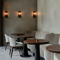 Ensemble de mobilier de café-restaurant : canapé banquette incurvé en velours beige, tables rondes en bois et chaises à assise en tissu pour café