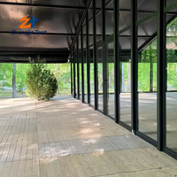 Tente de mariage de luxe avec cadre noir en verre, pavillon transparent pour fêtes en plein air, réceptions et événements de célébration