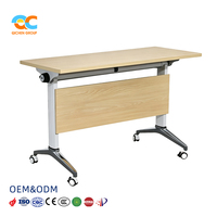 Table de séminaire pliante exécutive avec plateau en grain de bois clair, cadre blanc, roulettes, empilable pour réunions, salles de formation et salles de classe