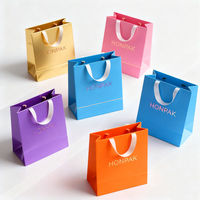 Sac en papier d'art de luxe avec poignée, logo personnalisé en relief et imprimé à l'écran pour un emballage haut de gamme de vêtements et de chaussettes