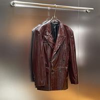 Veste de costume en cuir rouge foncé brillant à revers pointus et poches à rabat, longueur mi-longue, pour femme
