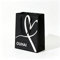 Sac cadeau en papier noir personnalisé avec logo imprimé blanc, poignées torsadées noires, sac fourre-tout tendance pour l'emballage d'accessoires de mode
