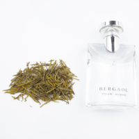 Parfum féminin, flacon en verre rectangulaire transparent, bouchon argenté, boîte grise, feuilles de thé vert, minimaliste, longue tenue