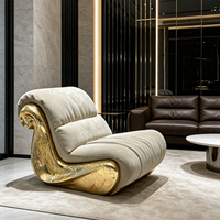 Canapé individuel de designer haut de gamme avec cadre sculptural doré et revêtement gris clair effet nuage pour la décoration intérieure