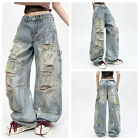 Jean long en denim style rétro américain, coupe courbée, effet vieilli et déchiré avec trous, peint avec des graffitis colorés