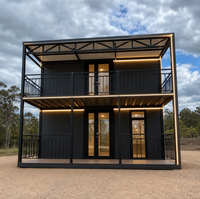 Bâtiment conteneur à deux étages, panneaux gris foncé, éclairage LED, unité modulaire préfabriquée pour bureau et logement, idéale pour l'hébergement sur chantier.