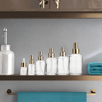Vente en gros de flacons pulvérisateurs ronds en verre transparent avec pulvérisateur en aluminium doré pour l'emballage de parfums et de cosmétiques