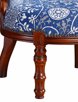Fauteuil capitonné antique avec dossier à carreaux bleus et blancs, assise à motif floral, garniture à clous et pieds tournés sculptés