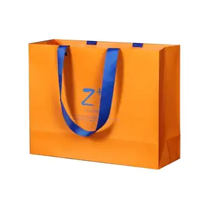 थोक कस्टम लोगो कपड़े शॉपिंग बैग पैकेजिंग उपहार सौंदर्य प्रसाधन के लिए संभाल के साथ क्राफ्ट पेपर बैग