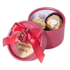 婚礼或促销礼品盒红色花和蝴蝶结丝带和心脏标签上的红色圆纸糖果盒子