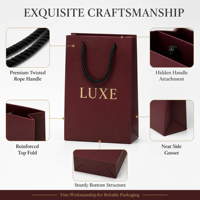 Sac cadeau en papier bordeaux de luxe avec logo en feuille d'or, poignées en corde torsadée renforcées, artisanat exquis