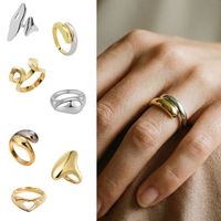 Bague en acier inoxydable au design minimaliste et surface lisse, finition couleur or et couleur argent.