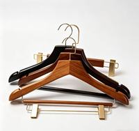 Cintre de présentation haut de gamme personnalisé en noyer noir, style vintage pour hôtel, avec crochets en laiton, et cintre à barre en bois de hêtre pour costumes avec pince lotus