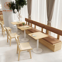 Mobilier de café-restaurant : banquettes en cuir marron avec structure en bois, tables et chaises en tissu pour café