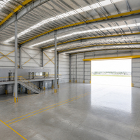 Hangar d'aviation avec pont roulant, espace intérieur haut plafond, plateforme de mezzanine et porte large pour avions