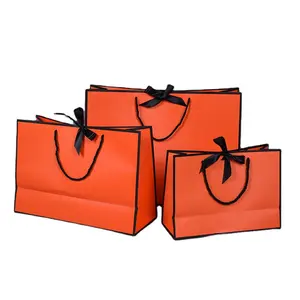 Stampa personalizzata Logo del marchio Design di lusso di abbigliamento al dettaglio regalo acquisto sacchetto di carta arancione con manico
