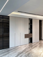Revêtement mural blanc minimaliste combiné à des vitrines en verre, des étagères ouvertes et des bandes lumineuses LED créant un design de rangement.