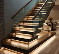 Escalier droit sur mesure de luxe, fabriqué avec des accents en nickel brossé et des marches larges, pour les lofts résidentiels haut de gamme