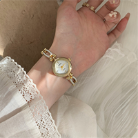 Montre à petit cadran de style bijou avec bracelet à maillons dorés pour présentation en cadeau
