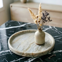 Plateau à thé minimaliste rond en marbre travertin pour salons modernes, tables basses et décoration d'hôtel.