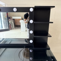 Table de maquillage moderne et élégante en chrome avec plateau en verre transparent, éclairage d'ambiance et cadre minimaliste