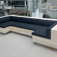 Canapé d'angle en marbre sur mesure, design moderne et écologique, structure beige en pierre, coussins en cuir noir, idéal pour appartement de luxe