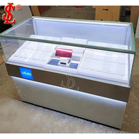 Vitrine moderne blanche et bois pour téléphones portables avec table d'expérience LED et panneau mural à crochets pour accessoires, aménagement de magasin sur mesure