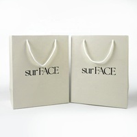 Sac de shopping en carton blanc épais de luxe avec logo personnalisé pour l'emballage de vêtements, de cosmétiques et de cadeaux