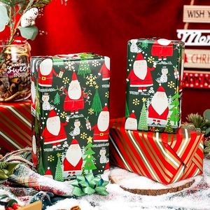 Papel de regalo de aluminio con diseño de Papá Noel y muñeco de nieve de doble cara en rojo y verde, con patrón diagonal rojo. - Product Image 1