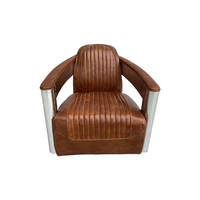Fauteuil club pivotant en cuir style aviateur, avec accoudoirs en aluminium, pour un intérieur rétro américain.