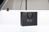 Sac fourre-tout en papier noir gaufré motif croco, avec logo personnalisé en feuille d'argent et poignée en cordon, idéal pour le commerce de détail haut de gamme et les cadeaux.