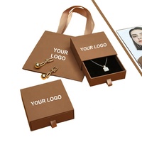Un ensemble de sacs en papier d'emballage liés aux bijoux, carte en papier et boîtes coulissantes à dessin avec logo personnalisé