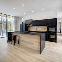Meubles de cuisine modernes bicolores avec îlot en bois clair, portes plates noires et rangement intégré pour appareils électroménagers