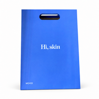 Sac en papier bleu Klein avec poignée découpée pour les boutiques de soins de la peau, les salons de beauté et les marques de cosmétiques, impression de logo personnalisée
