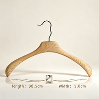 Design non conventionnel utilisé pour la présentation de vêtements avec des cintres en bois massif de couleur bois naturel