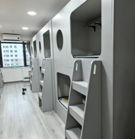 Lit-capsule moderne en bois avec rangement intégré, design populaire pour dortoirs, appartements, chambres, salons, auberges de jeunesse, aéroports et hôtels
