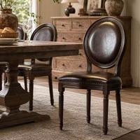 Chaise de salle à manger vintage française en cuir rembourrée, dossier rond, garniture cloutée, structure en bois massif pour usage domestique