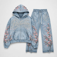 Ensemble survêtement streetwear personnalisé : sweat à capuche oversize zippé et pantalon de survêtement coupe droite, en denim déchiré, avec impression DTG et broderie de patchs