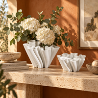 Vase en céramique blanche avec un design sculptural fluide pour fleurs et décoration intérieure