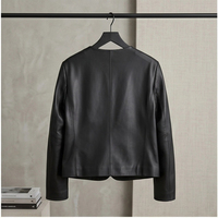 Veste en peau de mouton pour femme, noire, col rond, boutons-pression, poche poitrine unique, coupe courte minimaliste, style urbain