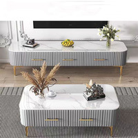 Table basse moderne en pierre frittée avec base grise cannelée et pieds en métal doré