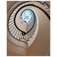 Escalier hélicoïdal courbé avec poutre continue en acier, marches en chêne massif, balustrade en verre et éclairage LED intégré