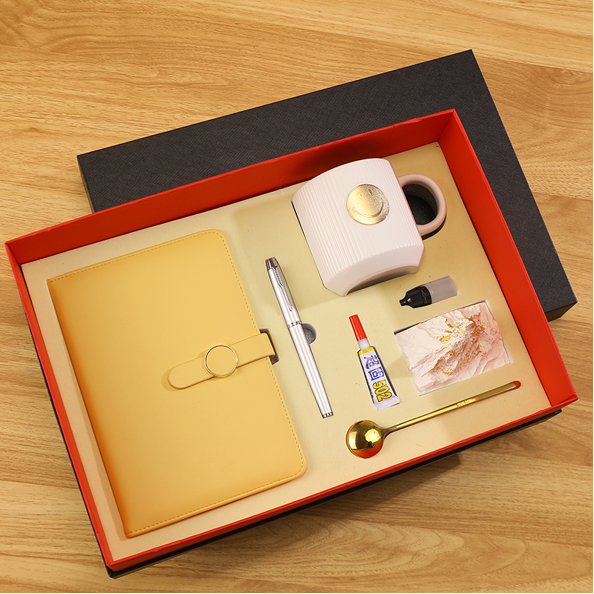 Cahier beige, stylo, tasse en céramique et coffret-cadeau aromathérapie