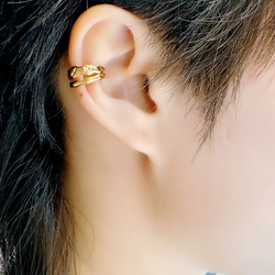 Un clip d'oreille jaune en forme d'os, environ