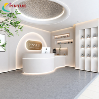 Comptoir de consultation de luxe personnalisé pour soins de la peau avec bureau ovale, base dorée et étagères encastrées pour produits – Magasin de beauté moderne
