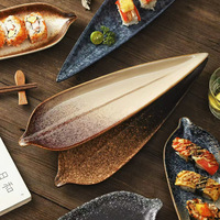 Plat en céramique élégant de style feuille avec bord naturel, idéal pour servir des apéritifs, des desserts, des fruits ou des sushis.