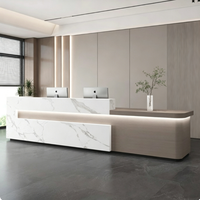 Comptoir de réception moderne personnalisé avec effet marbre et éclairage LED pour hôtel, immeuble commercial, hall d'entreprise