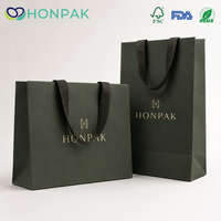 Sacs cadeaux en papier vert avec logo personnalisé, poignées en ruban, impression de logo doré pour l'emballage de vêtements de luxe HONPAK